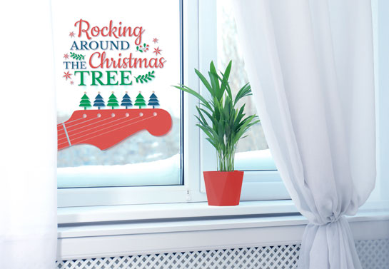 Rocking around the Christmas tree sign on a window with red guitar graphics