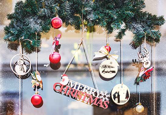 Hanging wooden decors to decorate an office window for Christmas