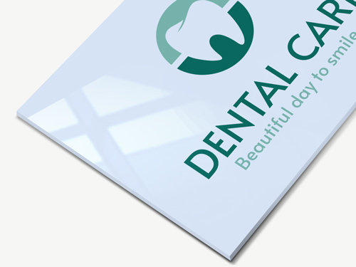 White acrylic sign for a dental clinic featuring the clinic's name and logo