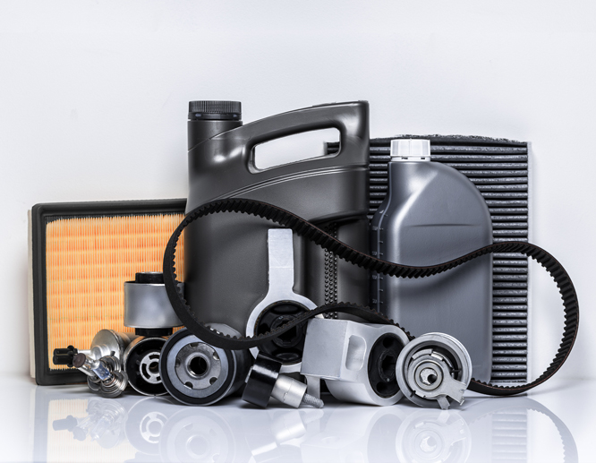 Assorted auto parts such as filters, engine components, fluid containers, and a timing belt arranged on a clean surface.