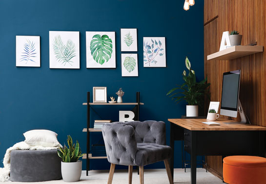 home office blue accent wall decorated with canvases