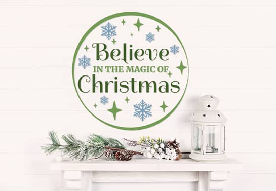 Circular Believe in the Magic of Christmas sign adhered to an interior wall