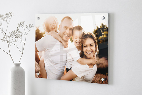 Custom acrylic sign showcasing a happy family portrait hanging on the wall