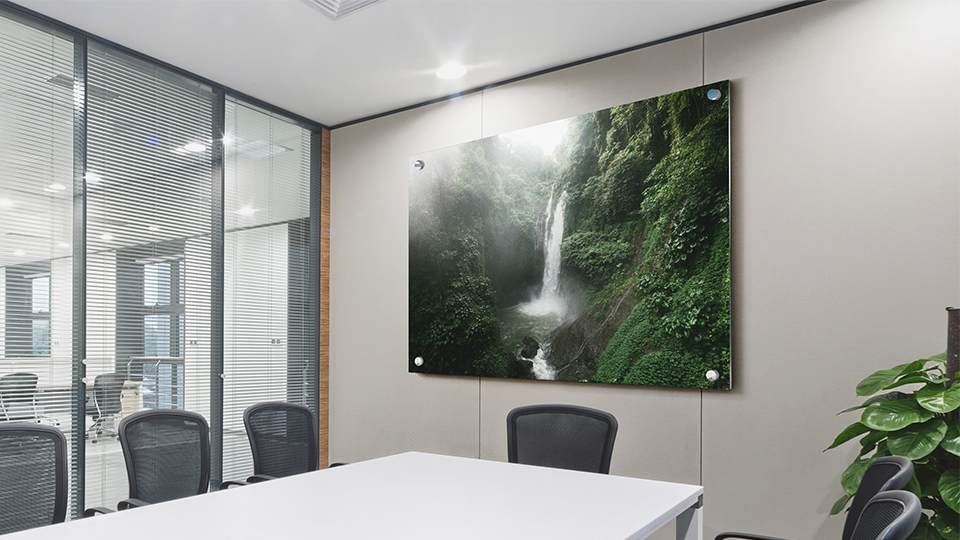 Large metal print showcasing a rainforest and waterfall in an office conference room