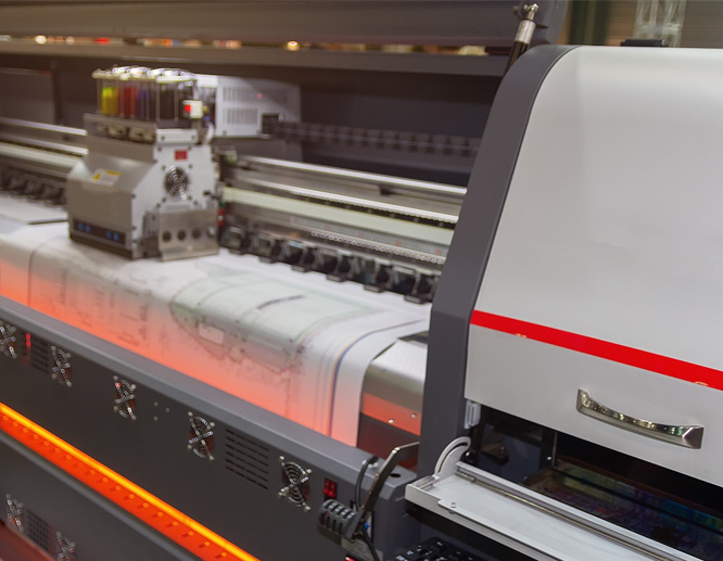 Industrial wide format printer producing large-scale print job in production facility.