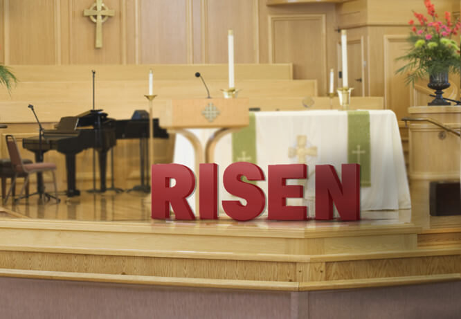 Dimensional red letters that spell Risen placed on a church stage