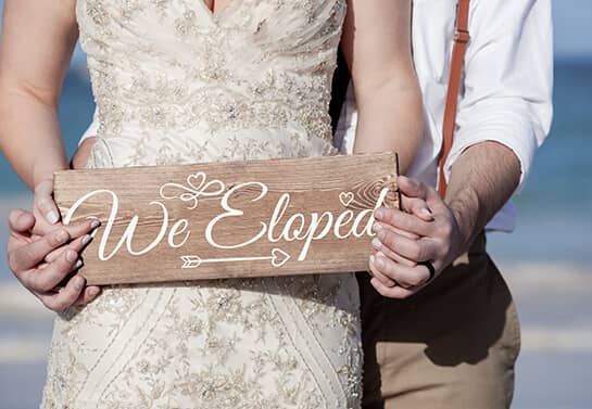 wedding sign idea with the text We Eloped in the hands of a couple