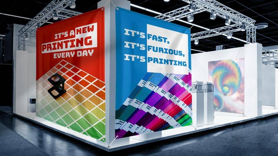  Event fabric banners attached from both sides of a trade show stand with business slogans