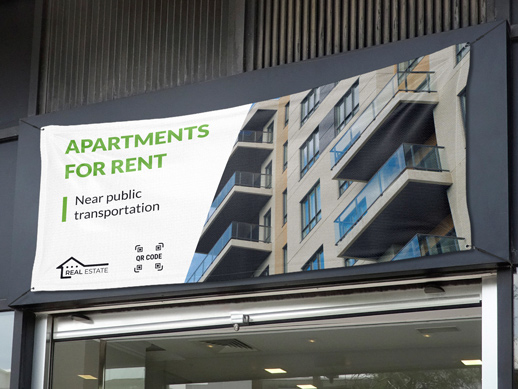 Rental fabric banner reading Apartments For Rent hanging from a building