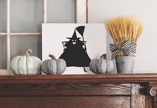 witch-themed Halloween mantel sign with grey decorative pumpkins