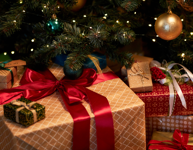 Christmas gift boxes of different sizes and colorful wrapping, set under the Christmas tree