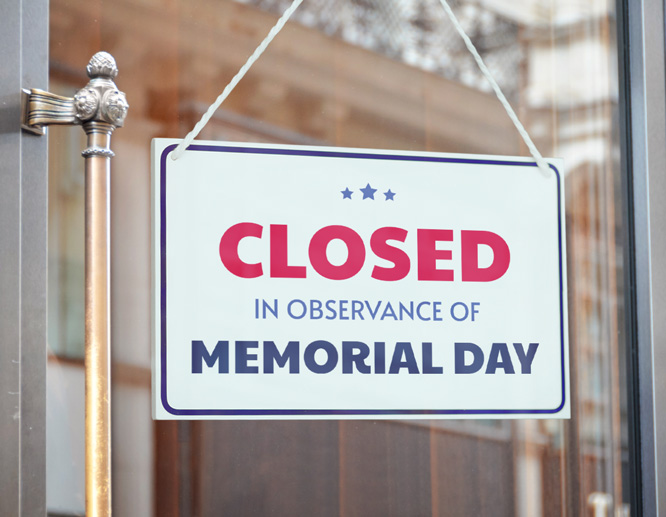 White Memorial Day closed sign mounted on a window