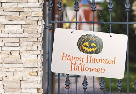 Happy Haunted Halloween hanging sign displayed on the fence