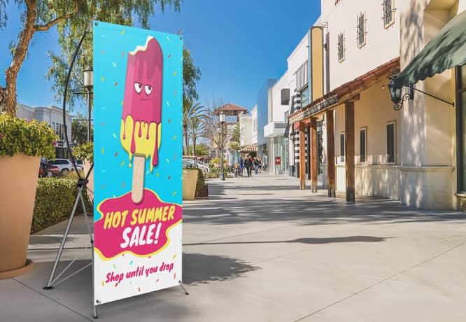 Vibrant summer sale X-stand banner placed at the storefront