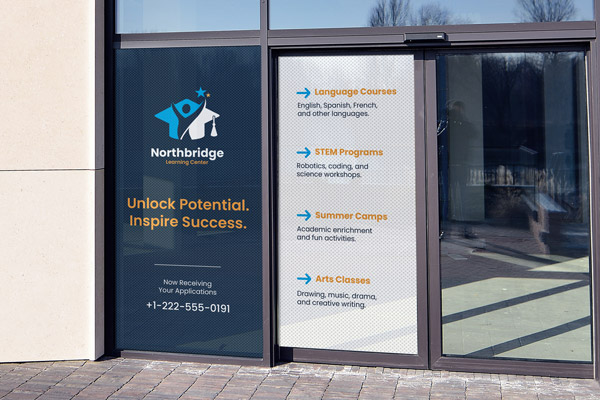 A learning center's perforated window decals applied to two windows, with graphics showcasing the business' branding and the offered services.