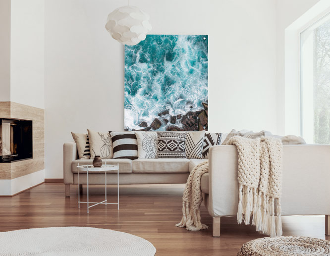 Metal sign wall art in modern living room with aerial view ocean print and neutral decor