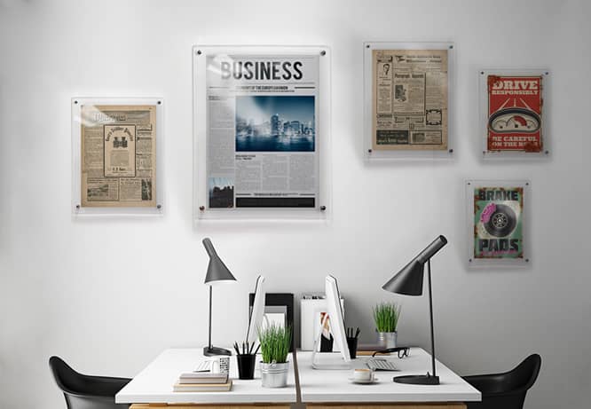 Old and new notable newspaper issue covers placed above a desk in the media company