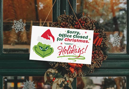 funny Christmas out of office sign with the Grinch’s face and a Happy Holidays note