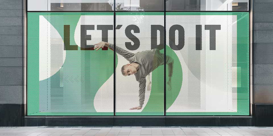 Advertising perforated window decal featuring a motivational quote and an athletic man posing