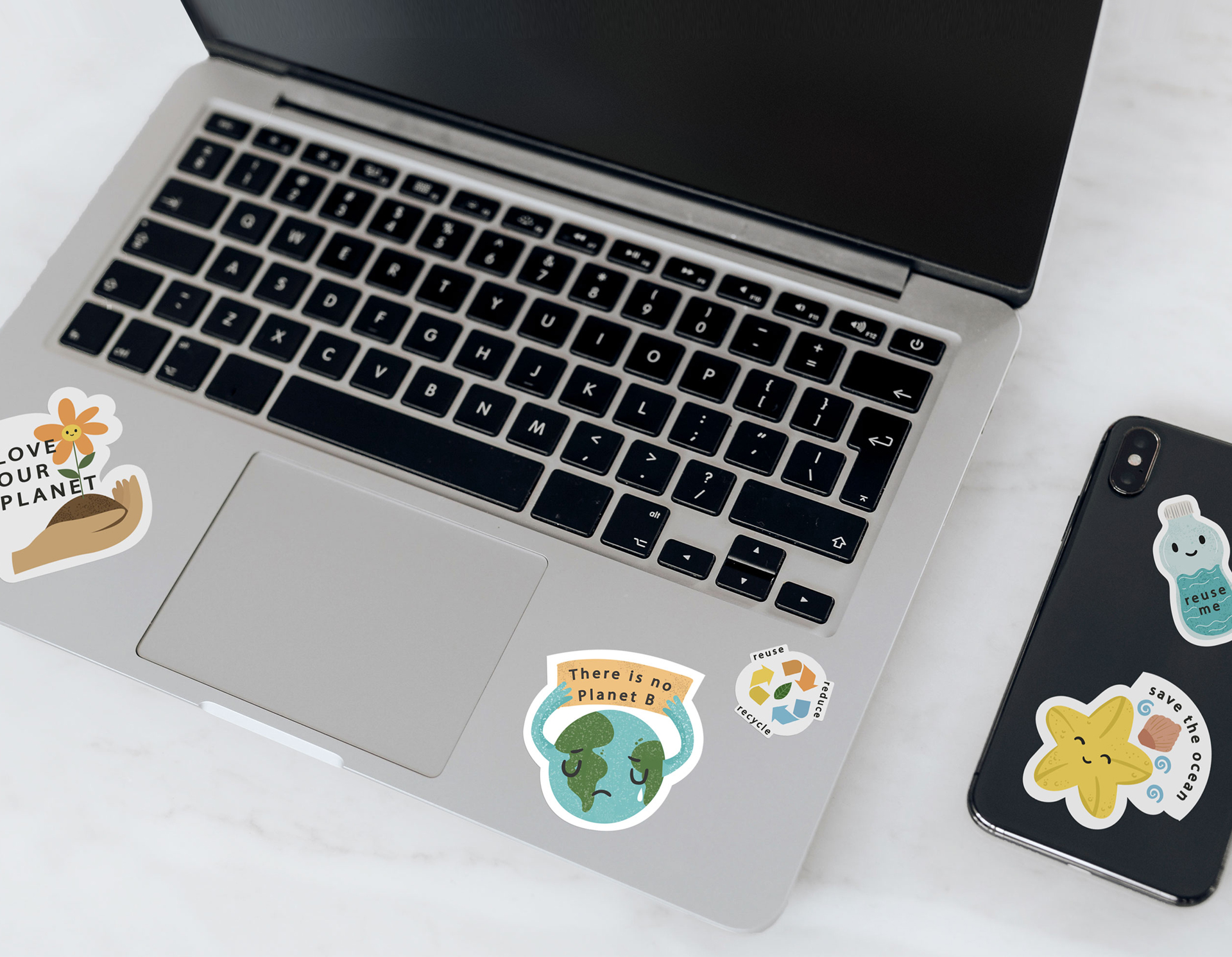 Stickers of different cuts and shapes applied to a laptop surface.