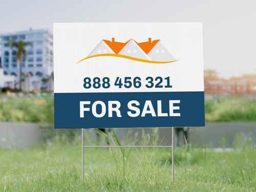 Bold real estate sign promoting a property for sale accompanied by contact details