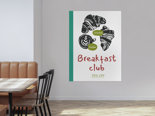 A restaurant styrene poster on the wall featuring an image of croissants and a text Breakfast Club. 