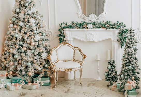 Multiple celebrity decorated Christmas trees near the wall