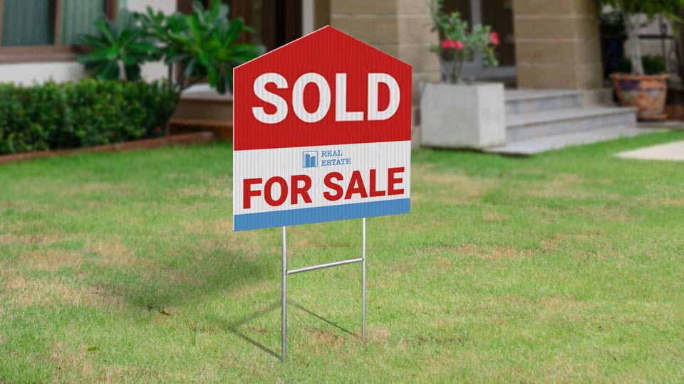 Custom-shaped sold real estate sign installed in the lawn