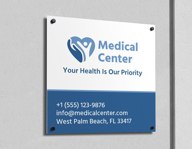A standard aluminum sign in blue and white showcases a logo of a medical center, as well as reads the contact information and address of the hospital.