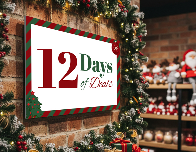 A wall-mounted Christmas sign for 12 days of deals is decorated with artificial fir branches, mistletoe fruit, and lights