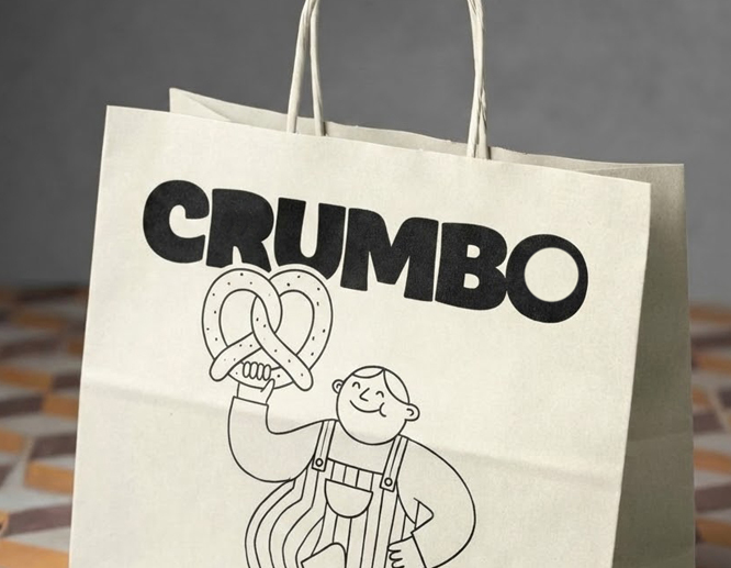 Beige tote bag with Crumbo text and cartoon character holding a pretzel.