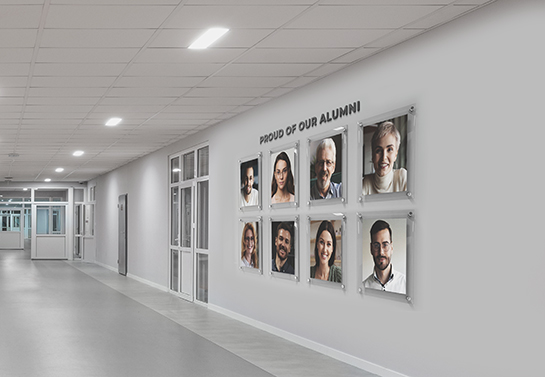 University alumni portraits hanged parallely on a hallway wall for motivational purposes