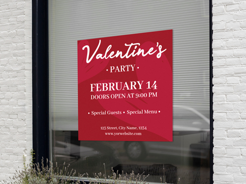 A red and white window cling advertising a Valentine's Day Party.