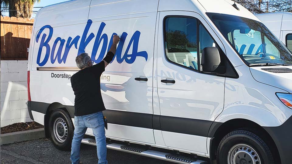 Installation process of van lettering for Barkbus handled by a professional