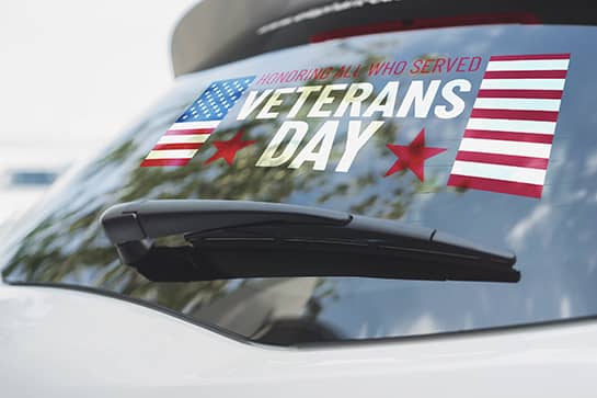 Veterans Day car sign with patriotic symbols displayed on the rear window