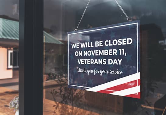 hanging Veterans Day closed sign in blue, red and white colors