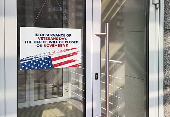 hanging office closed sign for Veterans Day displaying the US flag