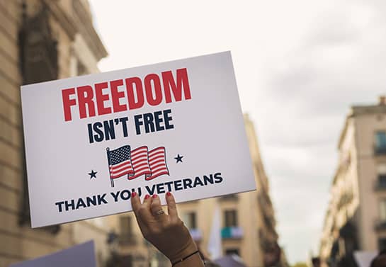 Veterans Day parade sign displaying a freedom quote