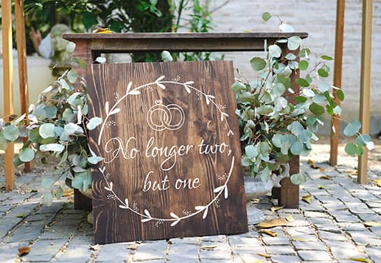 wooden wedding welcome sign idea with a quote and thematic elements