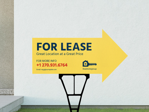 A yellow For Lease yard sign set up in front of a property directing people towards the entrance.