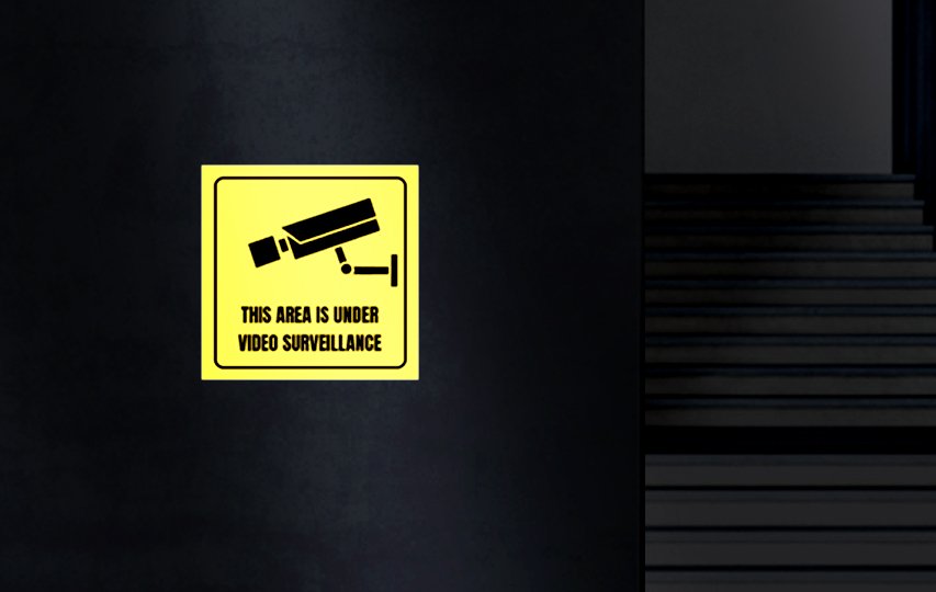 Yellow reflective lettering and decals informing about the area being under video surveillance. 